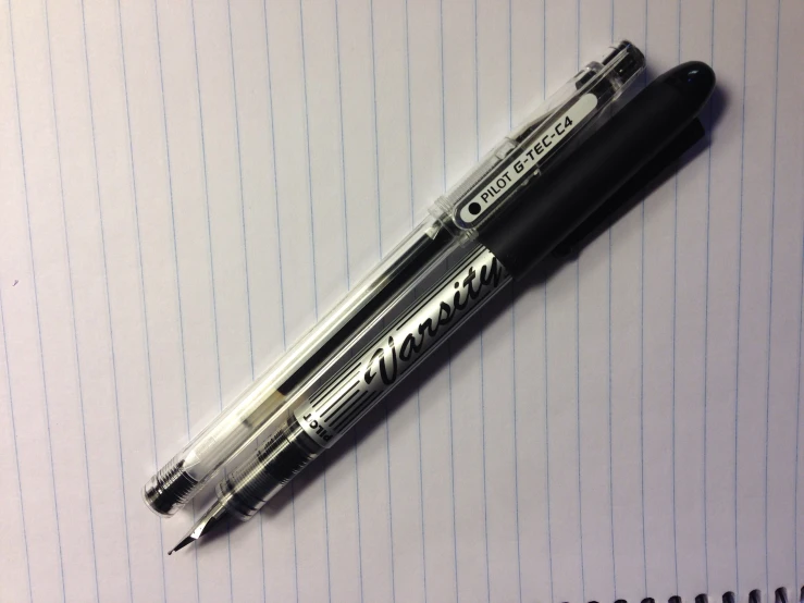 two different pens that are sitting on a notebook