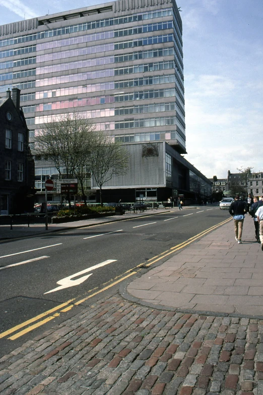 two people walking down the street, while two walk down the side walk