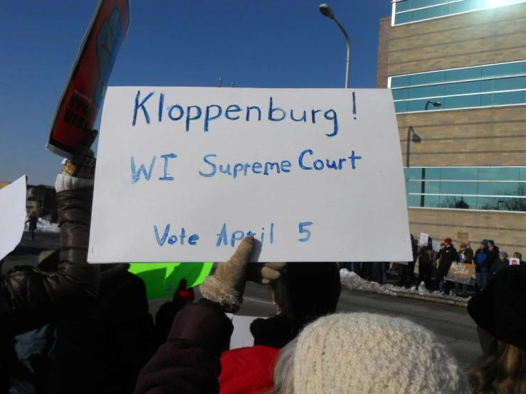 a group of protesters holds up a sign