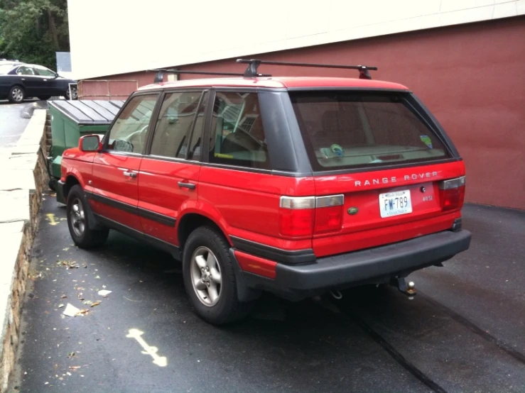 the red suv is parked beside the road