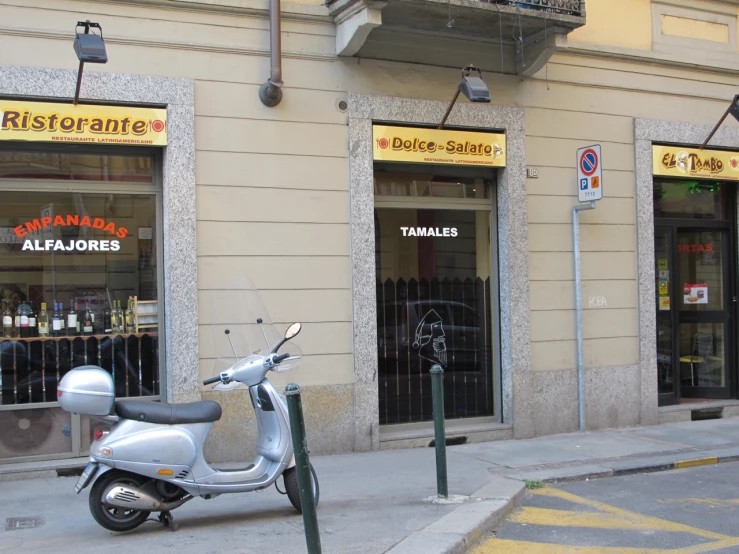 a white scooter is parked outside of a store