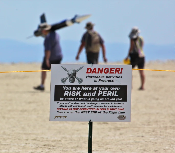 a sign attached to a line on a beach warning people that there are danger