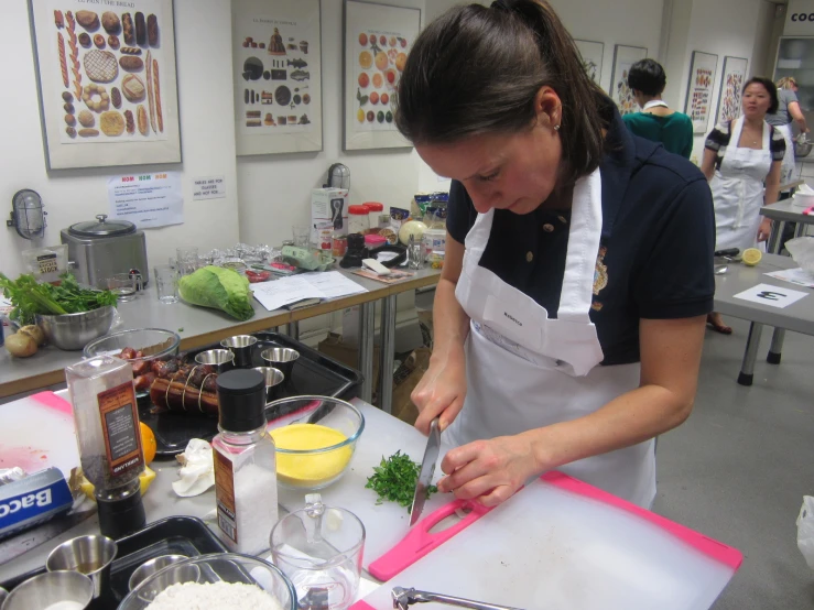 a woman in a kitchen cooking a dish with ingredients on the table