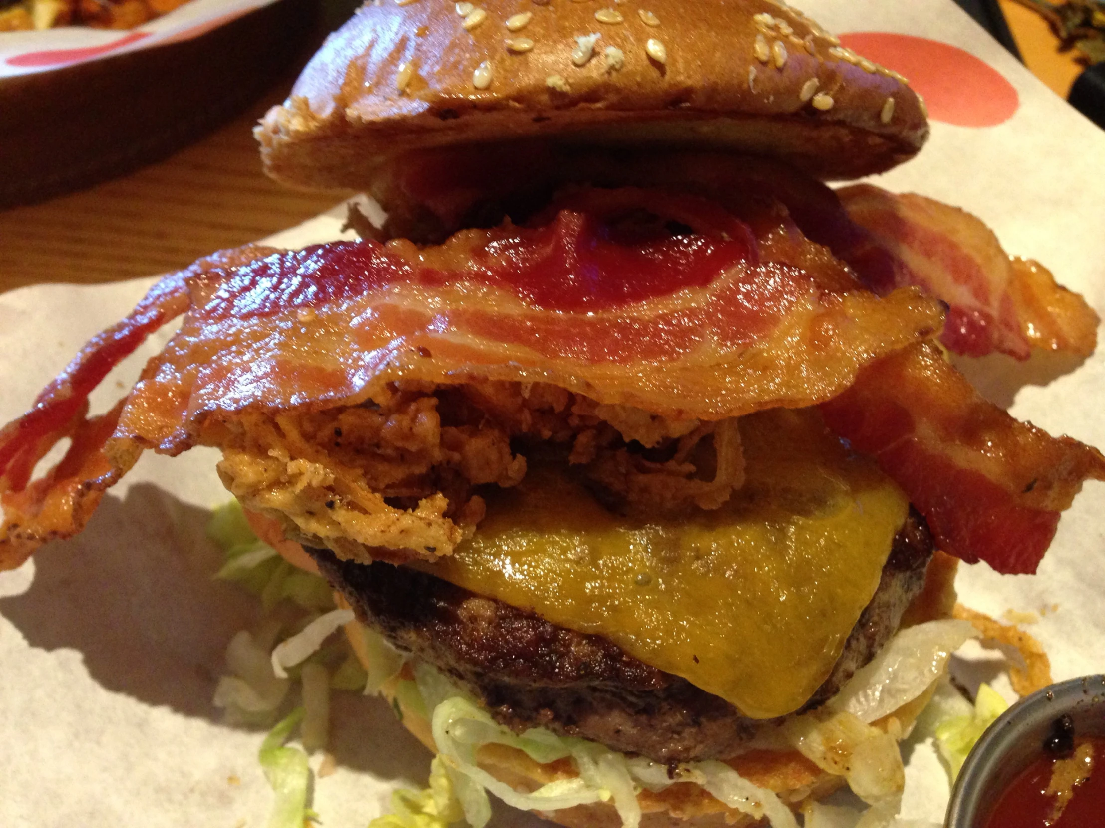 a double bacon burger sitting on top of a white paper