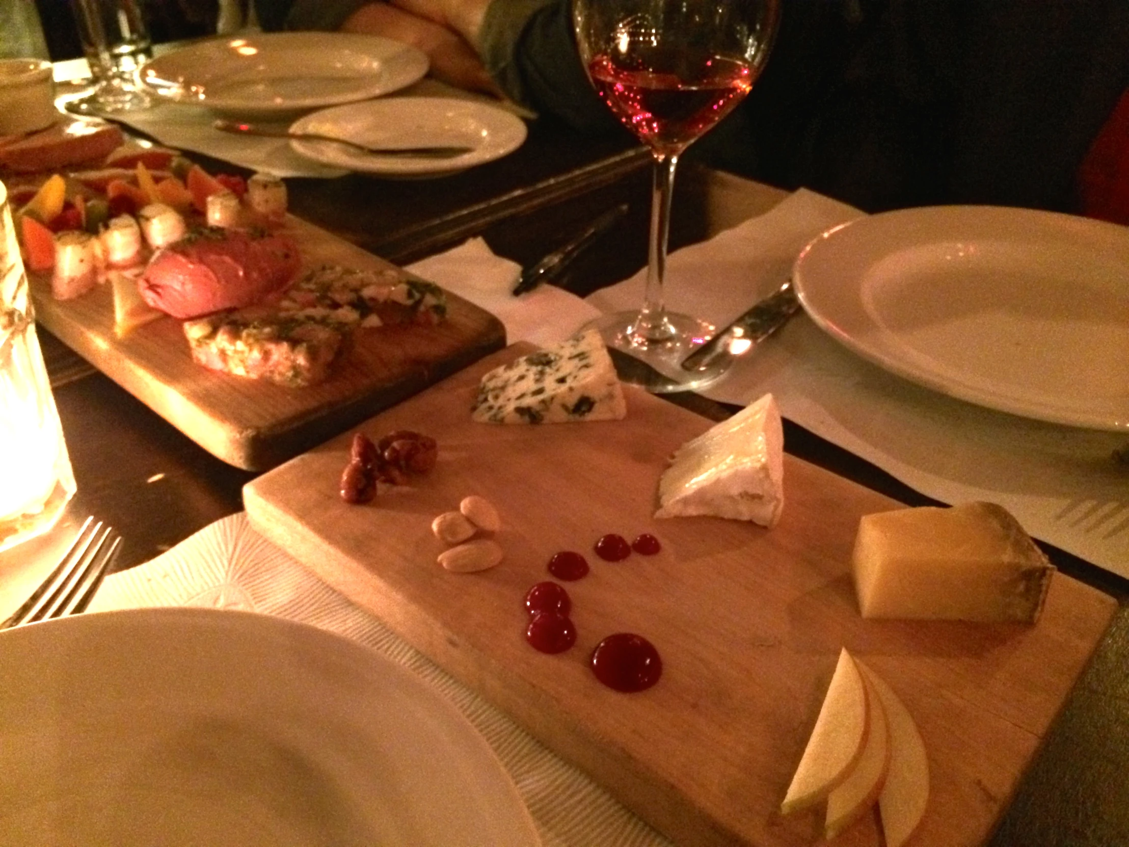 cheese and fruit sit on a chopping board