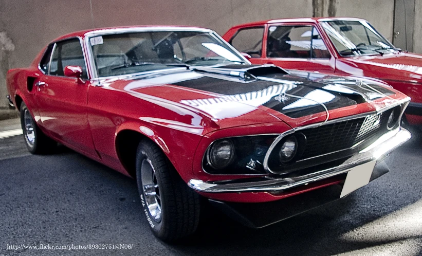 two vintage mustang cars are parked on the street