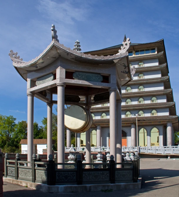 a clock tower next to a building with a sky background