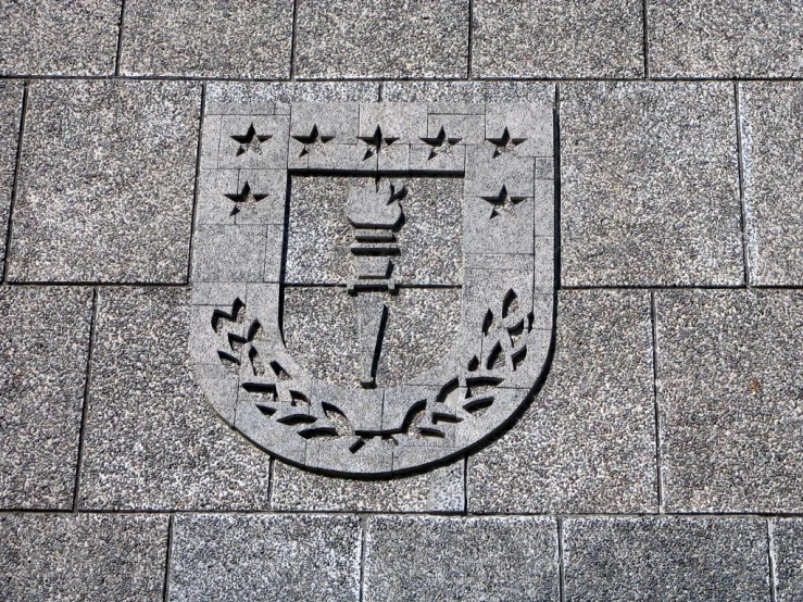 the emblem on a sidewalk shows people walking and a bus