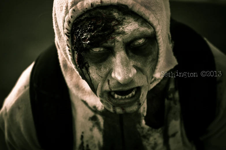 zombie looking man wearing a hood with his mouth wide open
