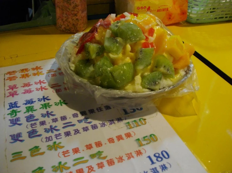 a paper plate of mixed fruit on a table