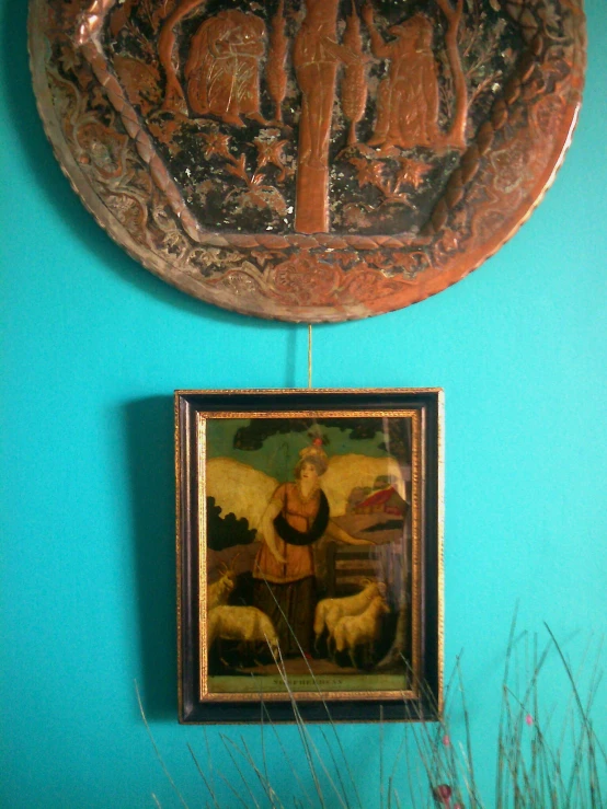 a painting hangs from the wall under a plaque on it