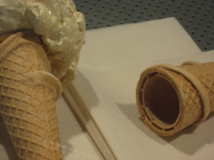 two cones of ice cream sit on a  board next to sticks
