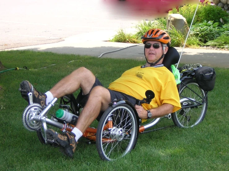 a man in a wheelchair on the grass wearing a helmet