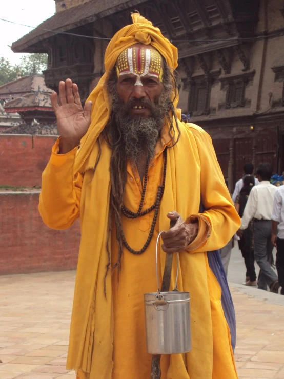 a man dressed in yellow standing on the sidewalk