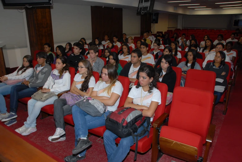 several people are in the audience listening to an assembly