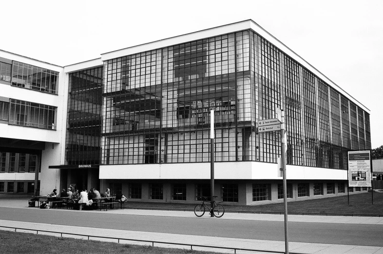 people sitting outside the front entrance of a large building