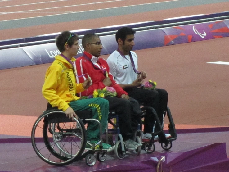 the three men in wheelchairs are all smiles for the camera