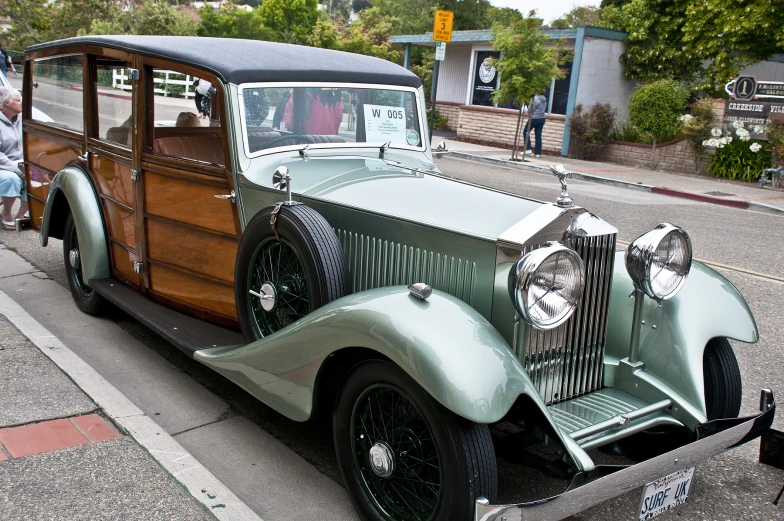 an old model car parked on a street