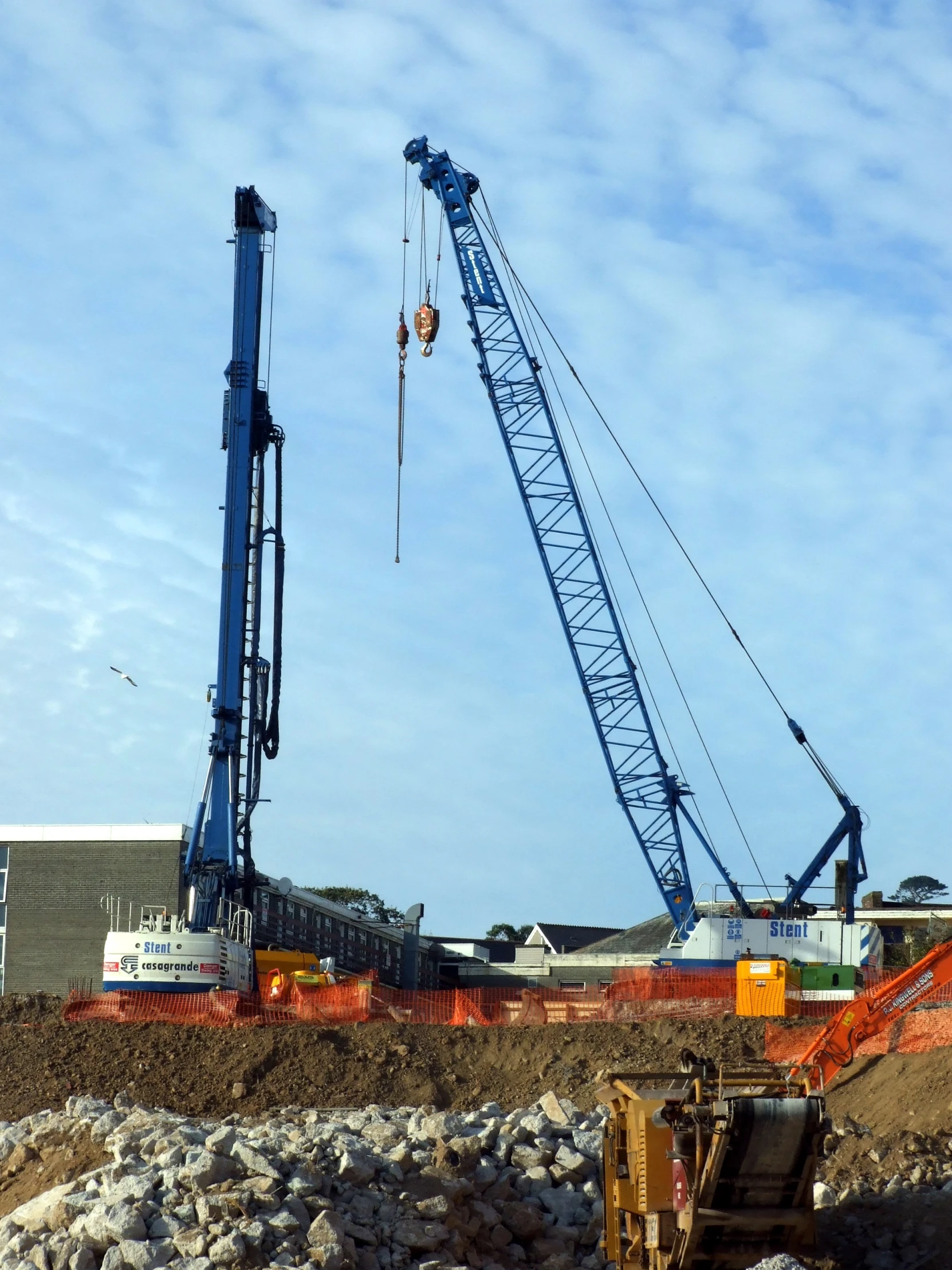 a crane sitting above construction work in the sun