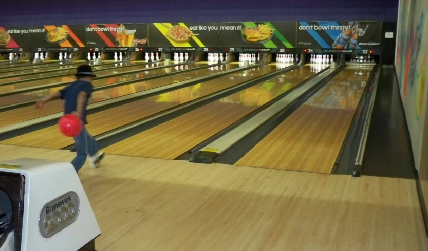 a man holding a red ball in bowling alley