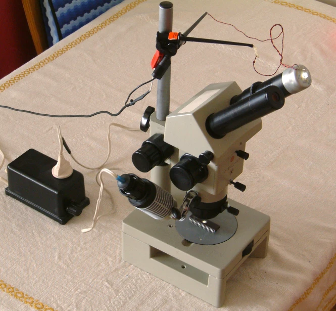 a microscope and its electronic device are on a table