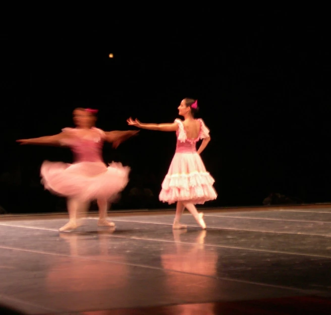 two people dance on a stage at night