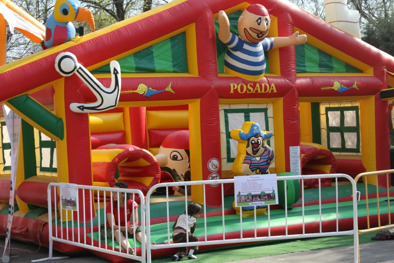 a red and yellow inflatable house with an octo figure above the entrance