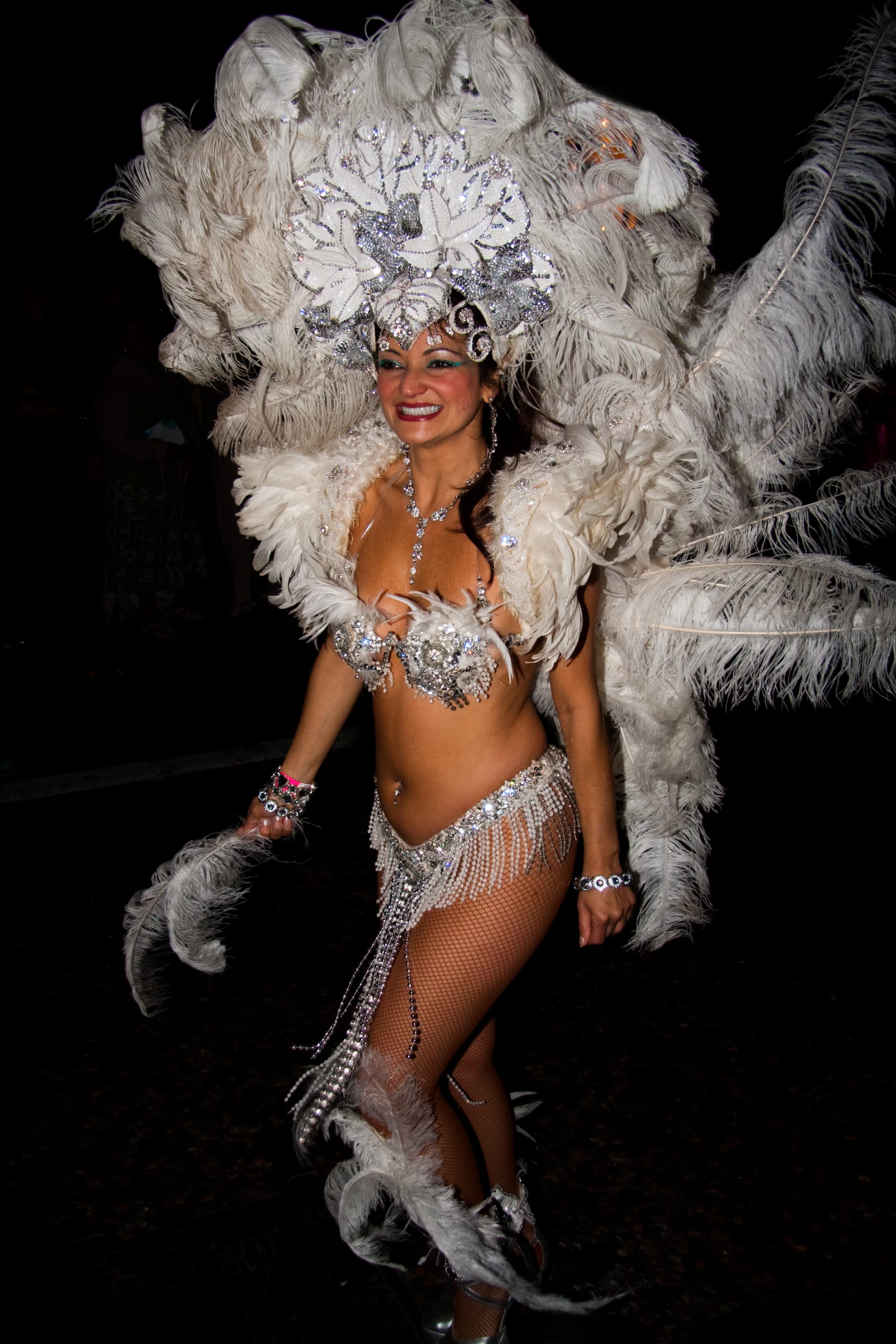 a woman in a silver costume is walking in the dark