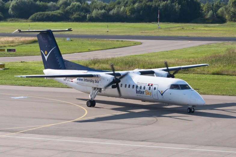 a plane is parked on a runway with grass in the background