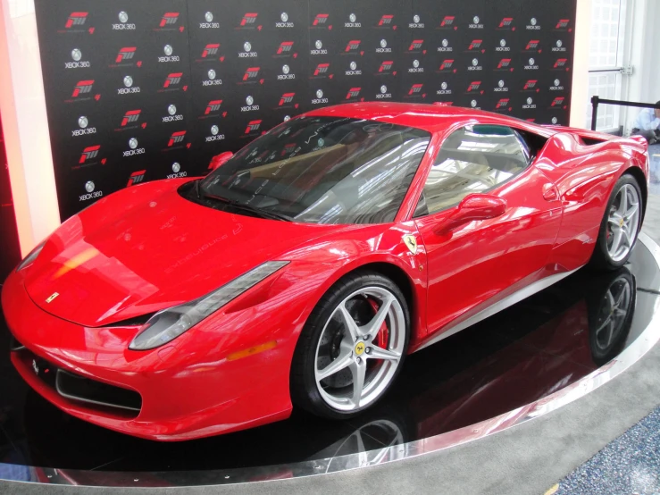 a red sports car parked in front of a black wall