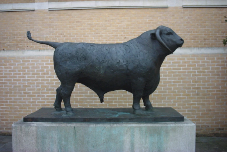 a statue of a cow near a building