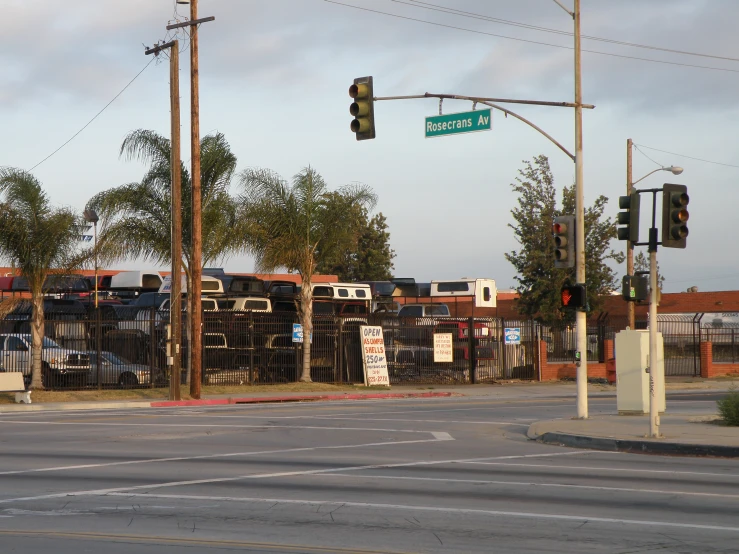 street signs and fencing on the corner of a crosswalk