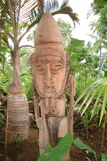 a statue of an indian person surrounded by trees and plants