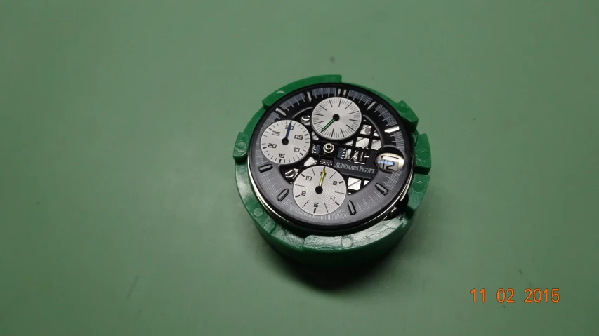 a watch with an array of timepieces on a green background