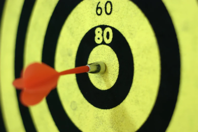 a dart hitting in the center of an orange target