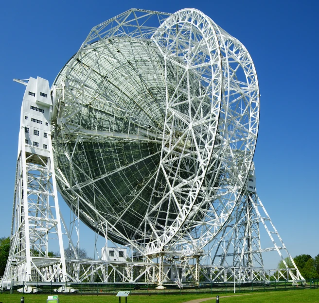 a large white ball shaped structure on top of a lush green field