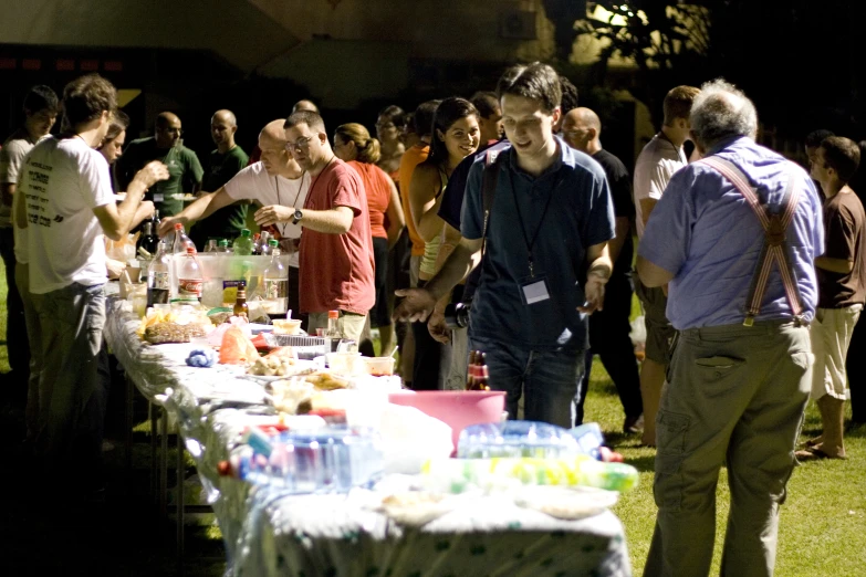 people standing around a table with lots of drinks