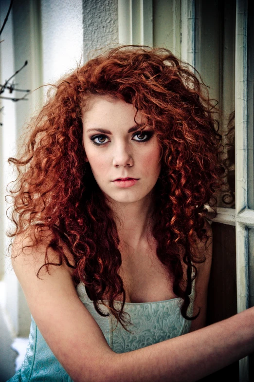 a pretty young woman with red hair looking at the camera