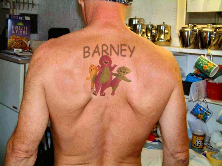 the man with his name tattoo is showing his back