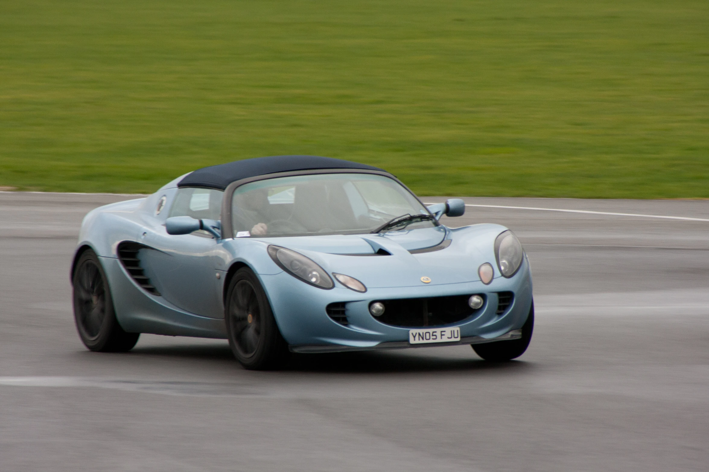 an all electric sports car with a top down on the track