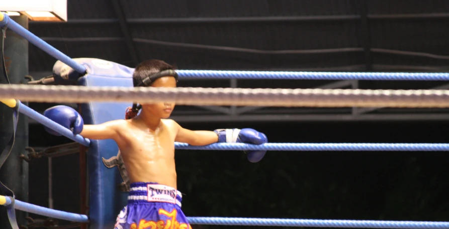 a young male boxer is practicing boxing in a ring