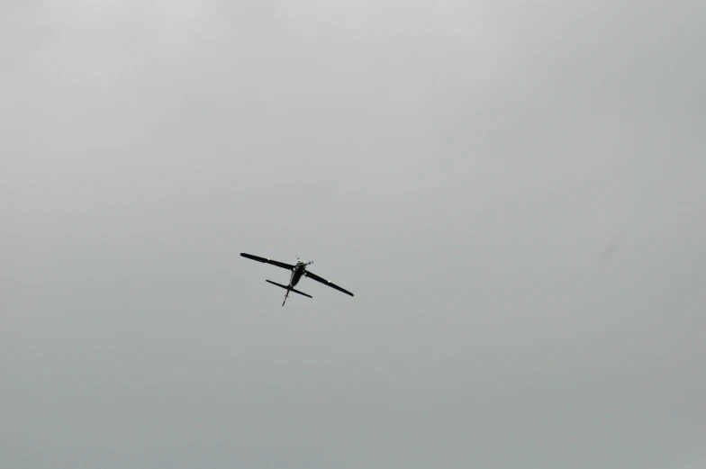 an airplane is flying in the sky during a cloudy day