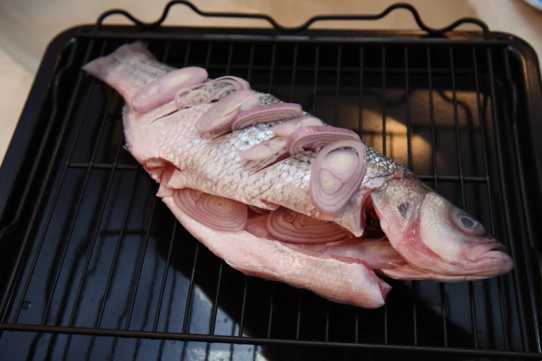 the whole fish is sliced up on a grill