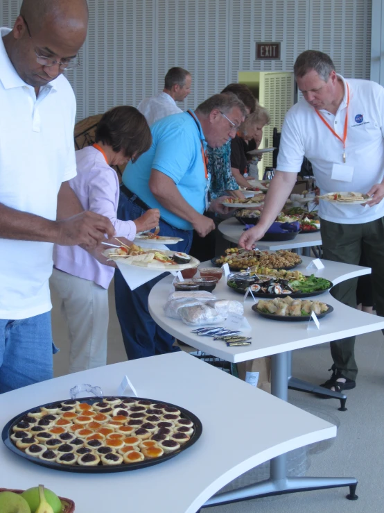 a group of people are getting plates of food