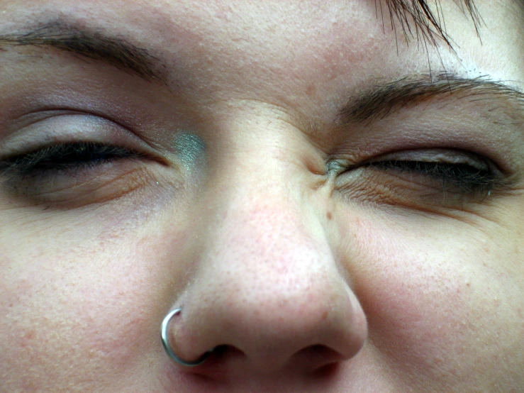 a close up of a woman's nose and nose ring