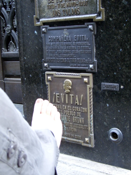 man pointing to two plaques on a wall