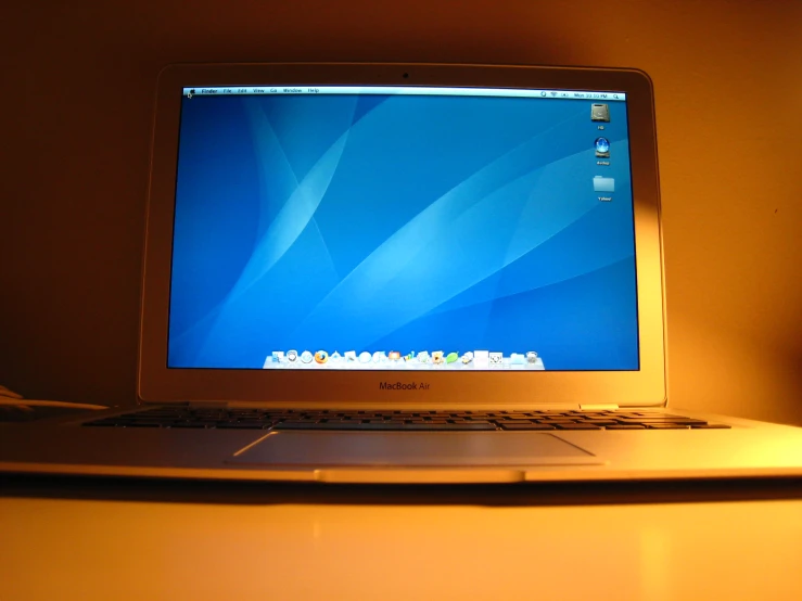 an apple computer is lit by the dim light