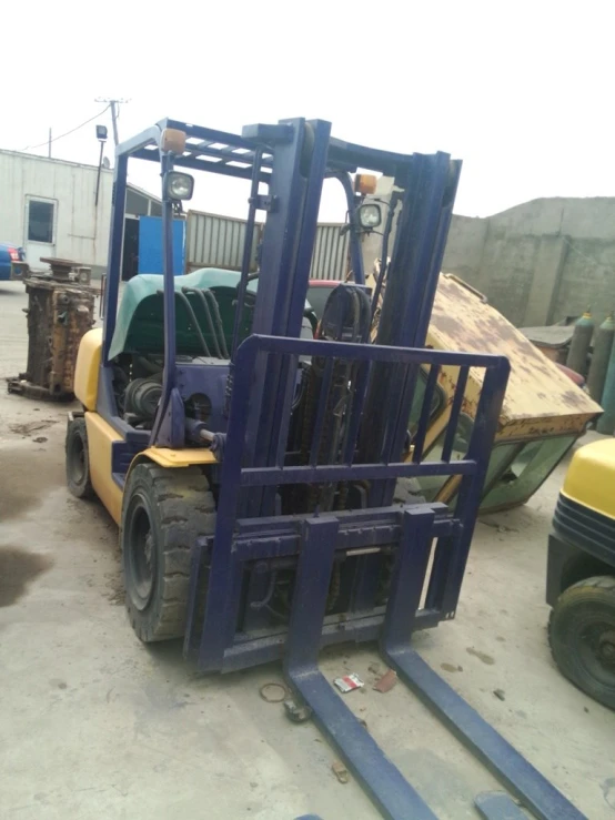 a forklift carrying large load next to wooden pallets