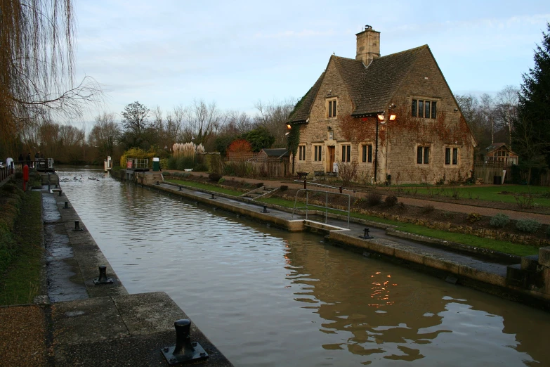 people are standing on the bridge looking out to the canal