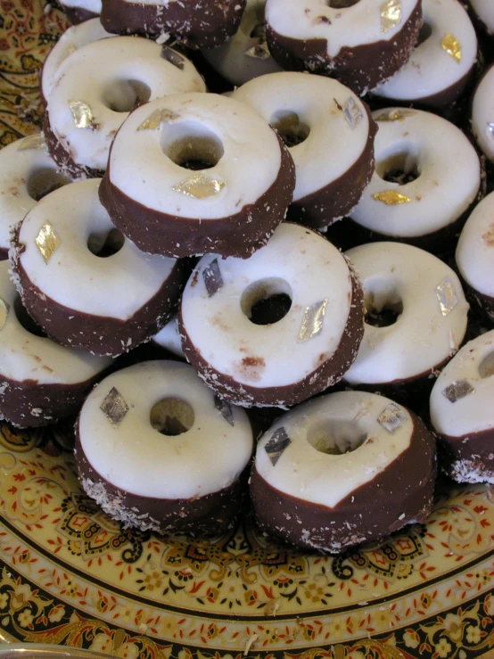 a bunch of chocolate donuts are piled up on a plate